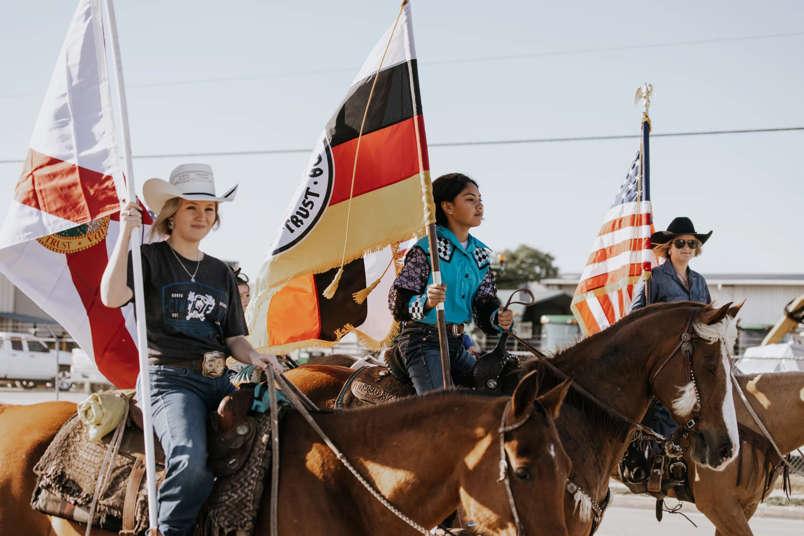 Three girls on horses bearing the Florida, Seminole Tribe of Florida, and United States Flags