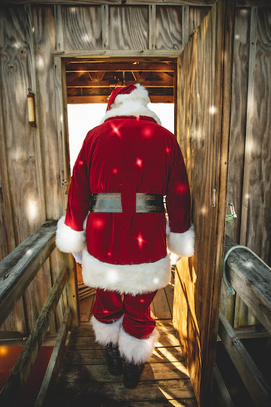 Santa Clause exiting a wood cabin