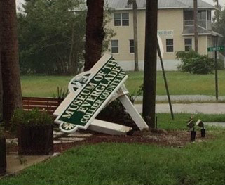 The damaged "Museum of the Everglades" sign after a hurricane