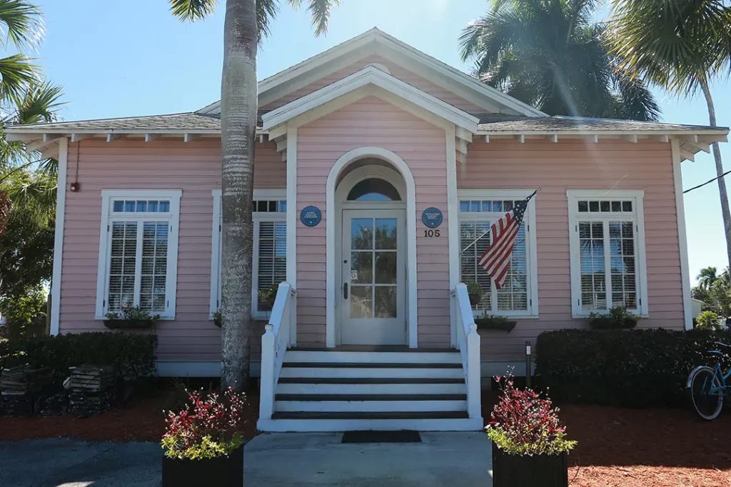 Building with pink siding surrounded by palm trees