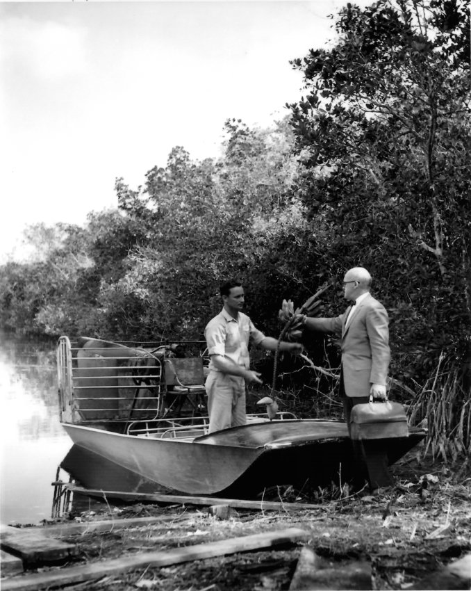 Black and white. Two men on a boat in the Everglades